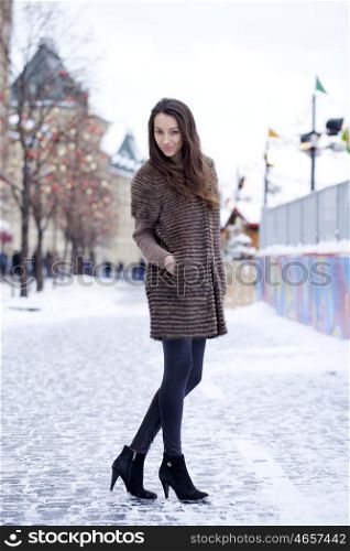 Young beautiful woman in stylish mink coat on a background of a winter street