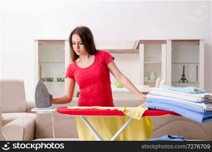 Young beautiful woman ironing at home  