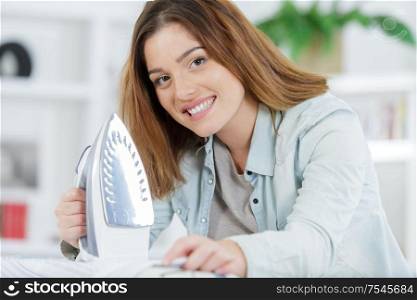 young beautiful woman ironing clothes