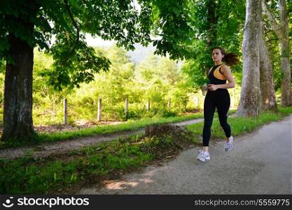 Young beautiful woman jogging in summer park. Woman in sport outdoors health concept