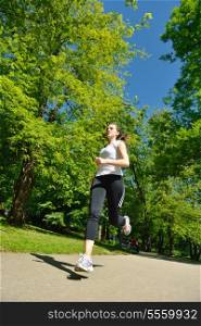 Young beautiful woman jogging in summer park. Woman in sport outdoors health concept