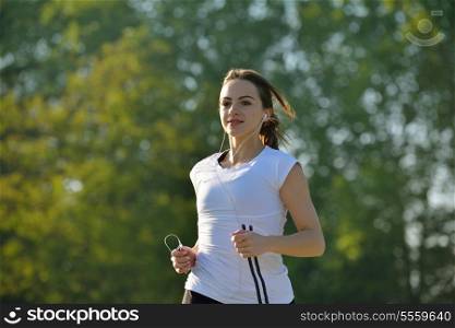 Young beautiful woman jogging on morning at park. Woman in sport outdoors health concept