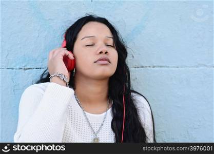 Young beautiful woman listening to music outdoors.