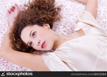 young beautiful woman lying in bed, studio