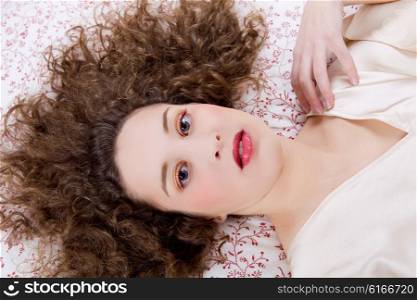 young beautiful woman lying in bed, studio