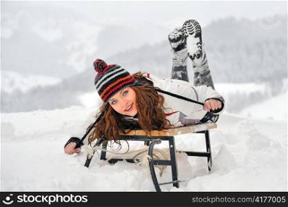 Young Beautiful Woman on sledge in winter time