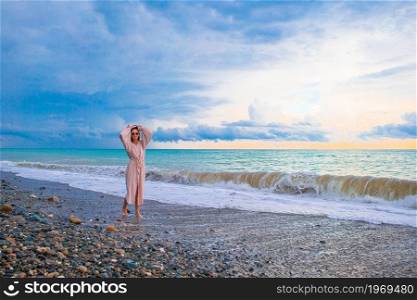 Young beautiful woman on the beach at sunset. Woman laying on the beach enjoying summer holidays looking at the sea