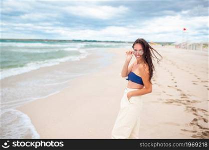 Young beautiful woman on the beach in storm. Young woman on the beach in the storm