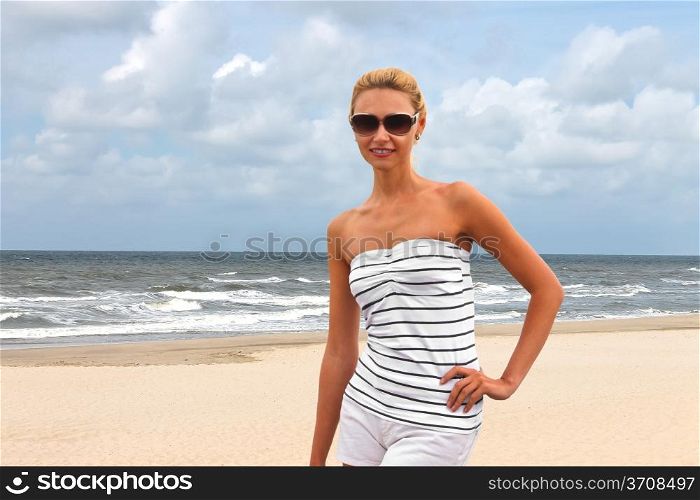 Young beautiful woman on the beach near the sea