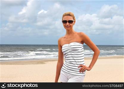 Young beautiful woman on the beach near the sea