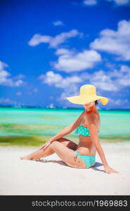 Young beautiful woman on the beach sunbathing. Young woman in hat on the beach vacation
