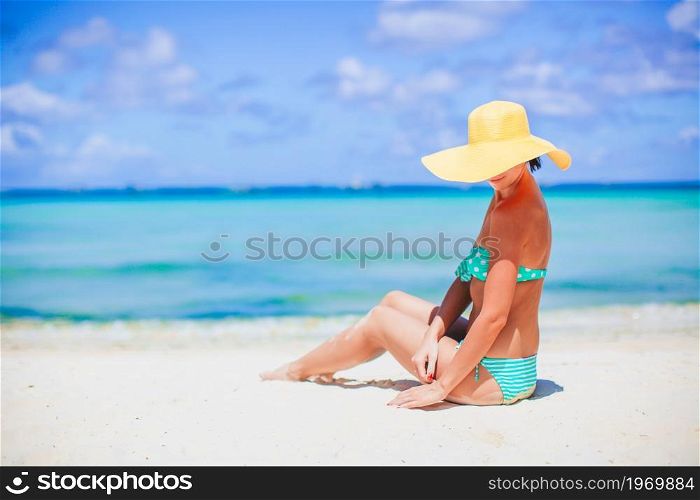 Young beautiful woman on the beach sunbathing. Young woman in hat on the beach vacation