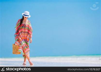 Young beautiful woman on the beach. Young fashion woman in green dress on the beach