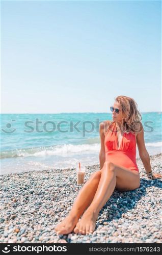 Young beautiful woman on white sand tropical beach.. Young fashion woman in green dress on the beach