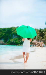 Young beautiful woman on white sand tropical beach. Young woman in white on the beach