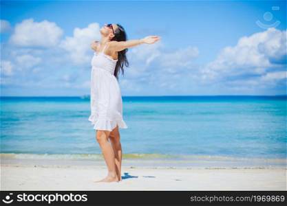 Young beautiful woman on white sand tropical beach. Young woman in white on the beach