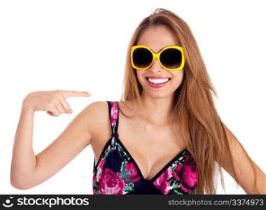 Young beautiful woman pointing out her yellow framed sunglass over isolated white background