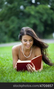 Young beautiful woman reading a book outdoor