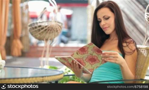 Young beautiful woman reading menu in restaurant