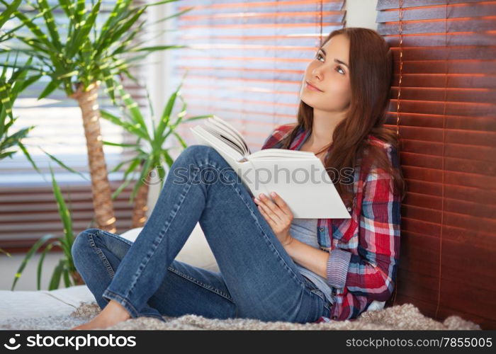 Young beautiful woman reading on the sofa