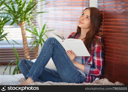 Young beautiful woman reading on the sofa