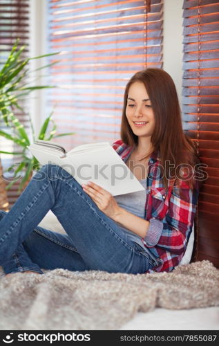 Young beautiful woman reading on the sofa