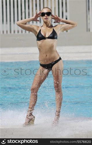 young beautiful woman relax and have fun with splashing water at hotel swimming pool young beautiful woman relax and have fun with splashing water at hotel swimming pool