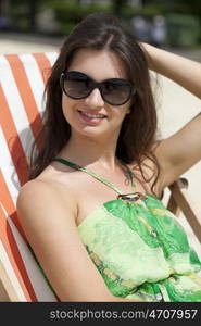 Young beautiful woman relaxing lying on a sun lounger