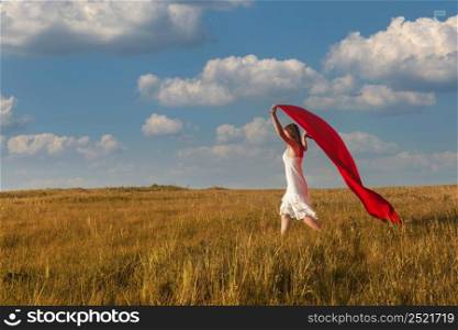 Young beautiful woman running while holding a red tissue