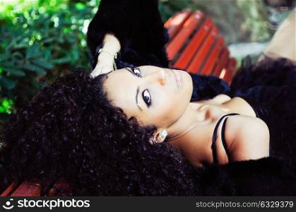 Young beautiful woman siting on bench in park