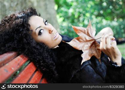 Young beautiful woman siting on bench in park