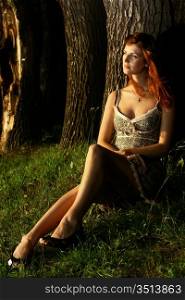 young beautiful Woman sitting under the tree in forest