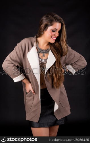 Young beautiful woman standing against black background