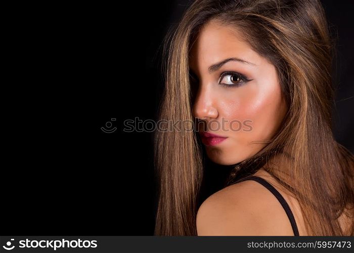 Young beautiful woman standing against black background