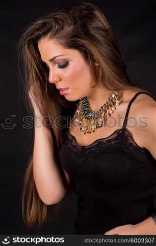 Young beautiful woman standing against black background