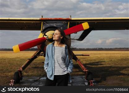 young beautiful woman standing near the plane. Traveling and technology. young beautiful woman standing near the plane. Traveling and technology.