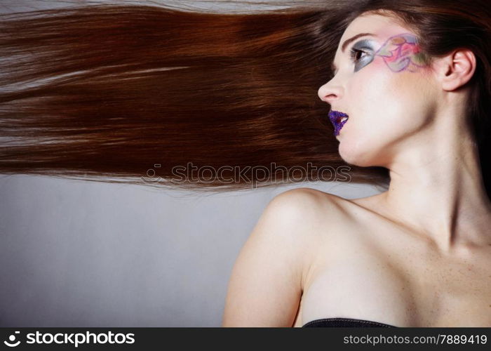 young beautiful woman straight long hair colorful make up grey background