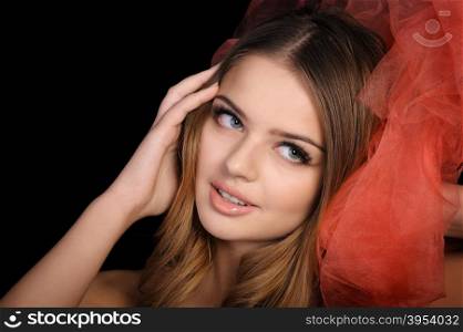 Young beautiful woman surpised and excited, portrait with red tulle isolated on white