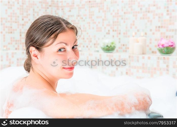 young beautiful woman taking a bath with foam