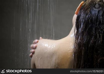 Young beautiful woman taking shower in a bathroom at home