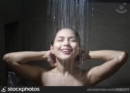 Young beautiful woman taking shower in a bathroom at home