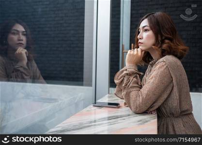 young beautiful woman thinking and looking at window