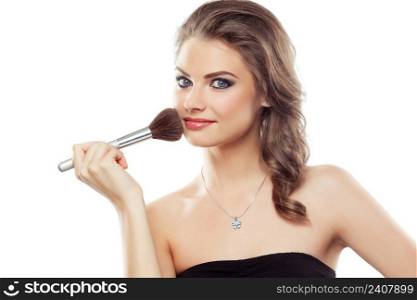 Young beautiful woman using a make-up brush, isolated on white