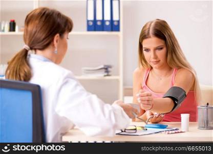 Young beautiful woman visiting doctor for blood pressure 