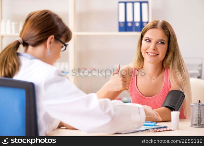 Young beautiful woman visiting doctor for blood pressure 