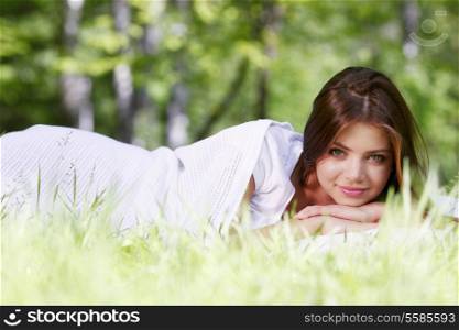 Young beautiful woman waking up on grass outdoors