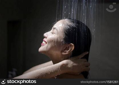 Young beautiful woman washing her hair in a bathroom at home