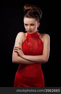 Young beautiful woman wearing a red dress over black background
