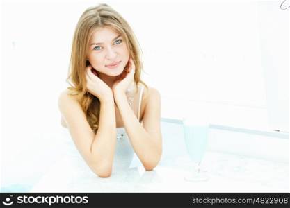 Young beautiful woman with a glass of drink sitting in a cafe