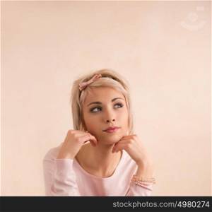 Young beautiful woman with blond short hair and hair band looking up and dreaming